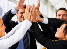 High five - Teamwork and team spirit - multi-ethnic pile of hands in the air
