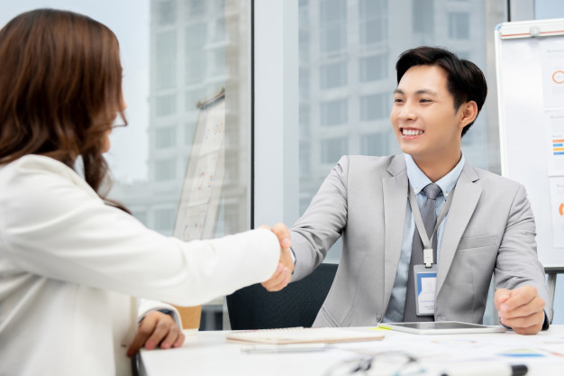 asian-businessman-making-handshake-with-businesswoman-office_8087-2830