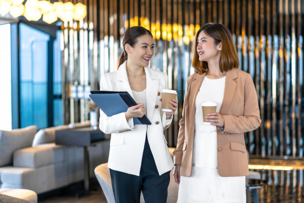 two-asian-businesswomen-talking-during-coffee-break-modern-office-coworking-space_41418-3673