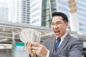 happy-face-asian-business-man-holding-money-us-dollar-bills-business-district-urban_1150-34754