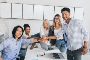 portrait-asian-young-man-his-african-friend-posing-beside-table-with-laptops-documents-it-web-designer-shaking-hands-with-new-employee-office_197531-3736