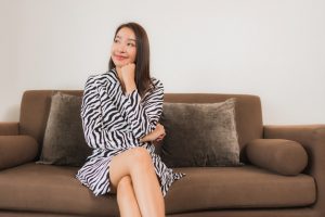 portrait-beautiful-young-asian-woman-smile-relax-sofa-living-room-interior_74190-12562