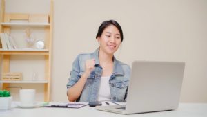 young-asian-woman-working-using-laptop-desk-living-room-home-asia-business-woman-success-celebration-feeling-happy-dancing-home-office_7861-1480